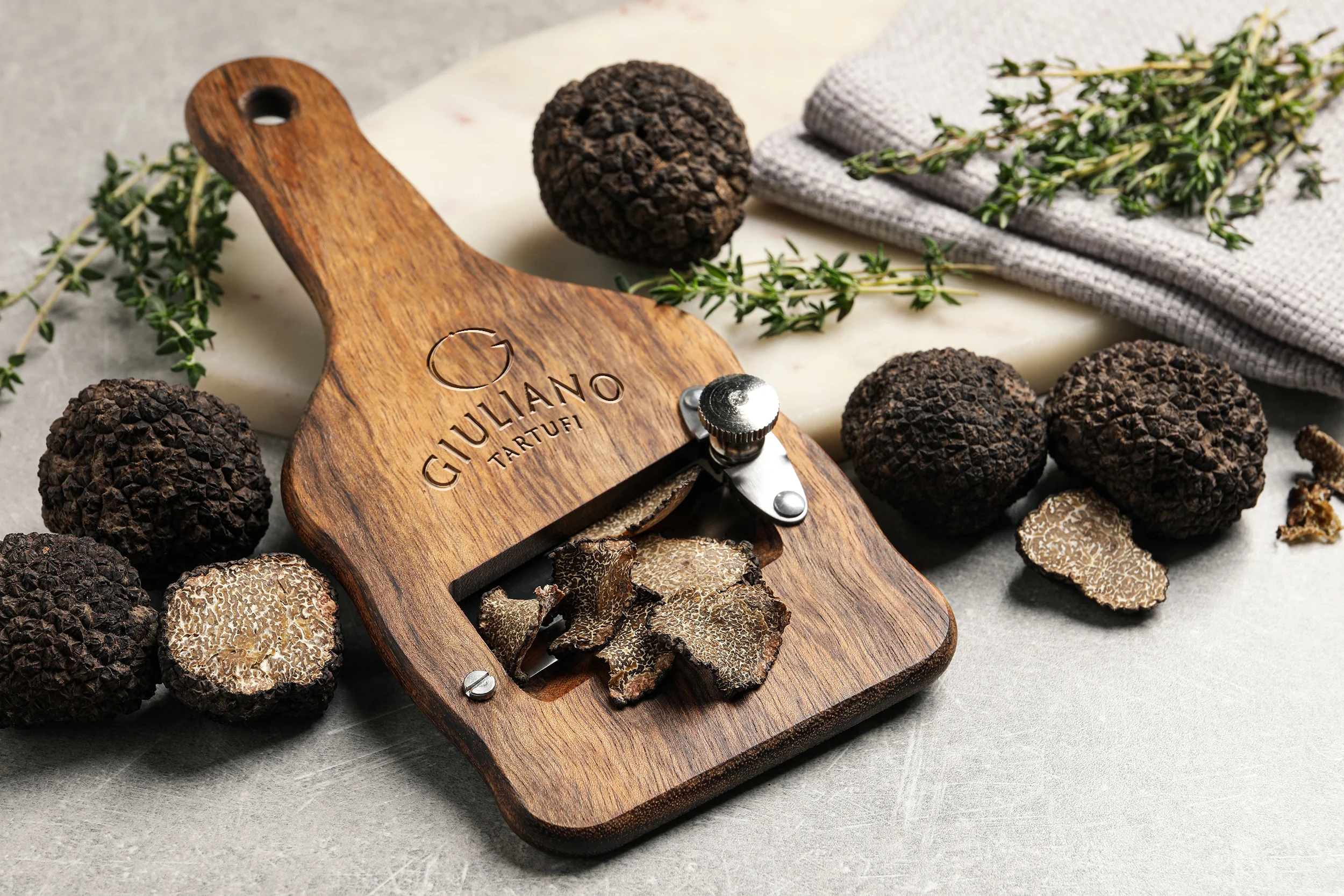 Affetta Tartufi firmato Giuliano Tartufi con scaglie di tartufo nero sprigionate sul piano di lavoro.