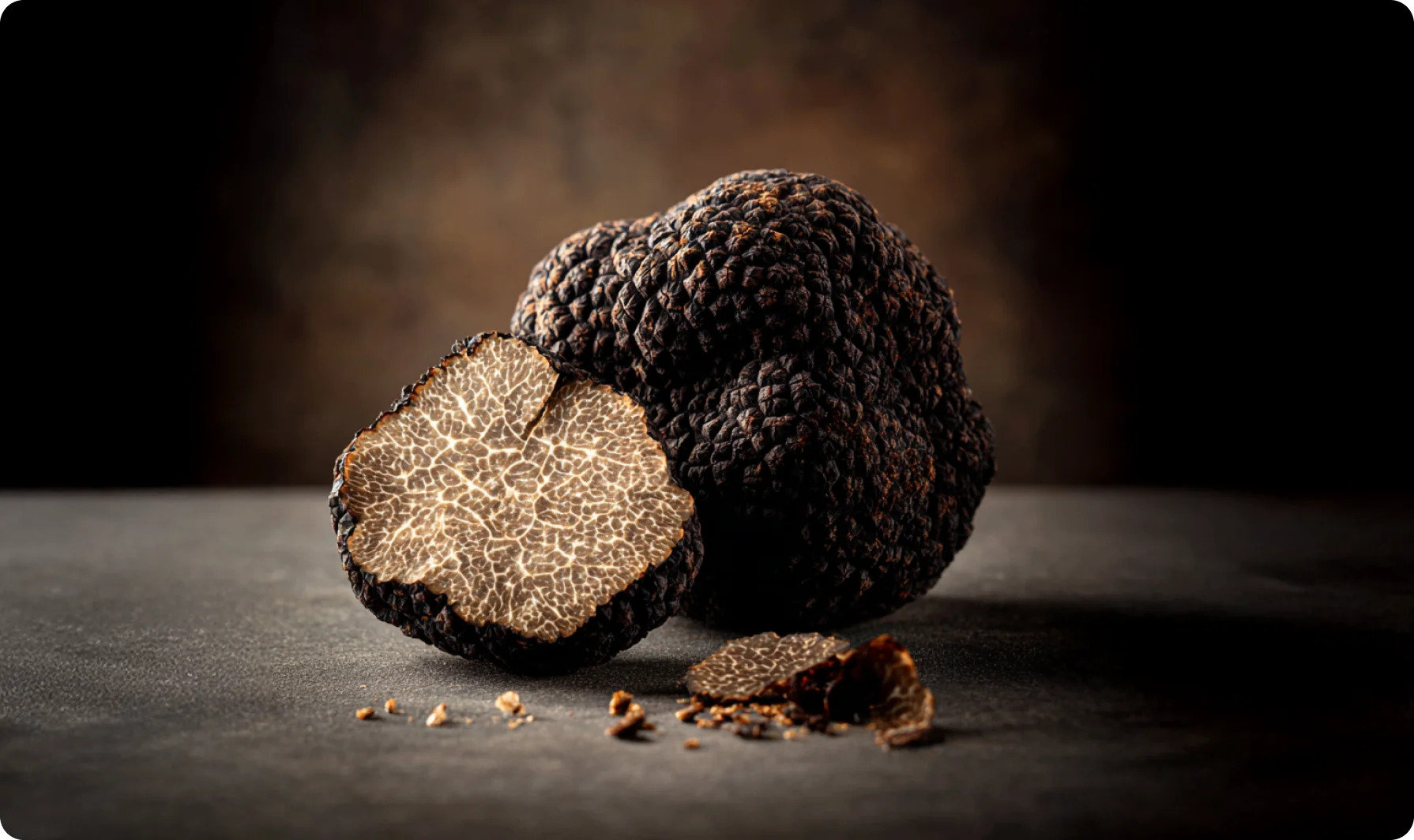 Primo piano di un tartufo nero affettato su un tagliere di legno scuro